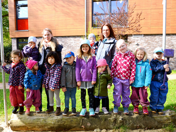 Kinder stehen zusammen mit Erzieherinnen draußen, Kita-Konzept, Albertinen Kindertagesstätte Volksdorf in Hamburg