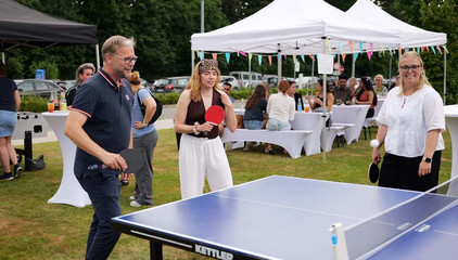Prof. Dr. med. Matthias Grünewald spielt mit Mitarbeitenden Tischtennis an einer Tischtennisplatte beim Sommerfest 2026 auf dem Gesundheitscampus Volksdorf des Evangelischen Amalie Sieveking Krankenhauses, der Residenz am Wiesenkamp, des Feierabendhauses Volksdorf und der Albertinen Kindertagesstätte Volksdorf.