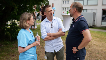 Priv.-Doz. Dr. med. Johannes Kluwe, Prof. Dr. med. Matthias Grünewald und eine Kollegin in Funktionskleidung unterhalten sich beim Sommerfest 2026 auf dem Gesundheitscampus Volksdorf des Evangelischen Amalie Sieveking Krankenhauses, der Residenz am Wiesenkamp, des Feierabendhauses Volksdorf und der Albertinen Kindertagesstätte Volksdorf. 